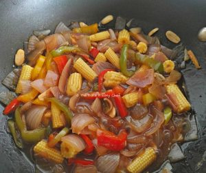 Soy sauce is added to the baby corn mix