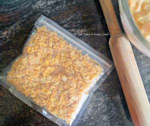 Crush cornflakes in a plastic bag
