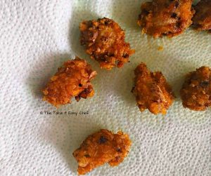 Drain off the excess oil from the fried popcorn chicken pieces