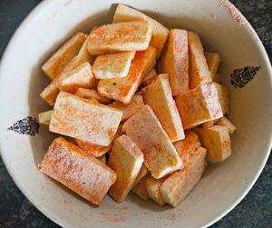 Sliced paneer pieces are coated in the chilli powder-corn flour mix