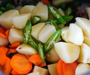 Add mutton, potatoes, carrot, green peas, green chillies, pepper, and salt
