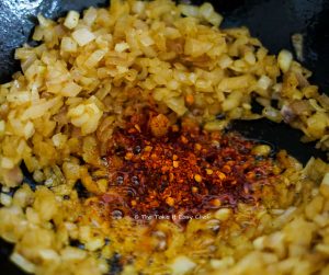 Add chilli flakes to the onions